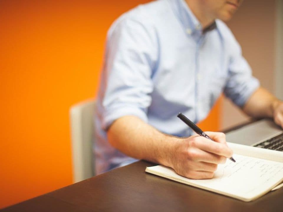 A desk with printed charts, a laptop and notes during a data review