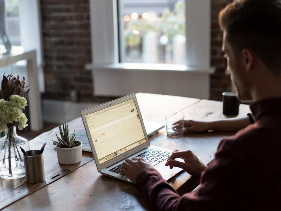 A person working on a laptop at a desk